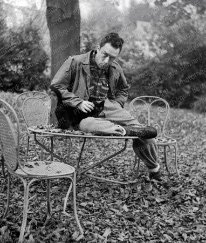 F819 Albert Camus assis avec son chat à Bougival, dans la propriété de Guy Shoeller pendant la pièce de théâtre Caligula, novembre 1945.